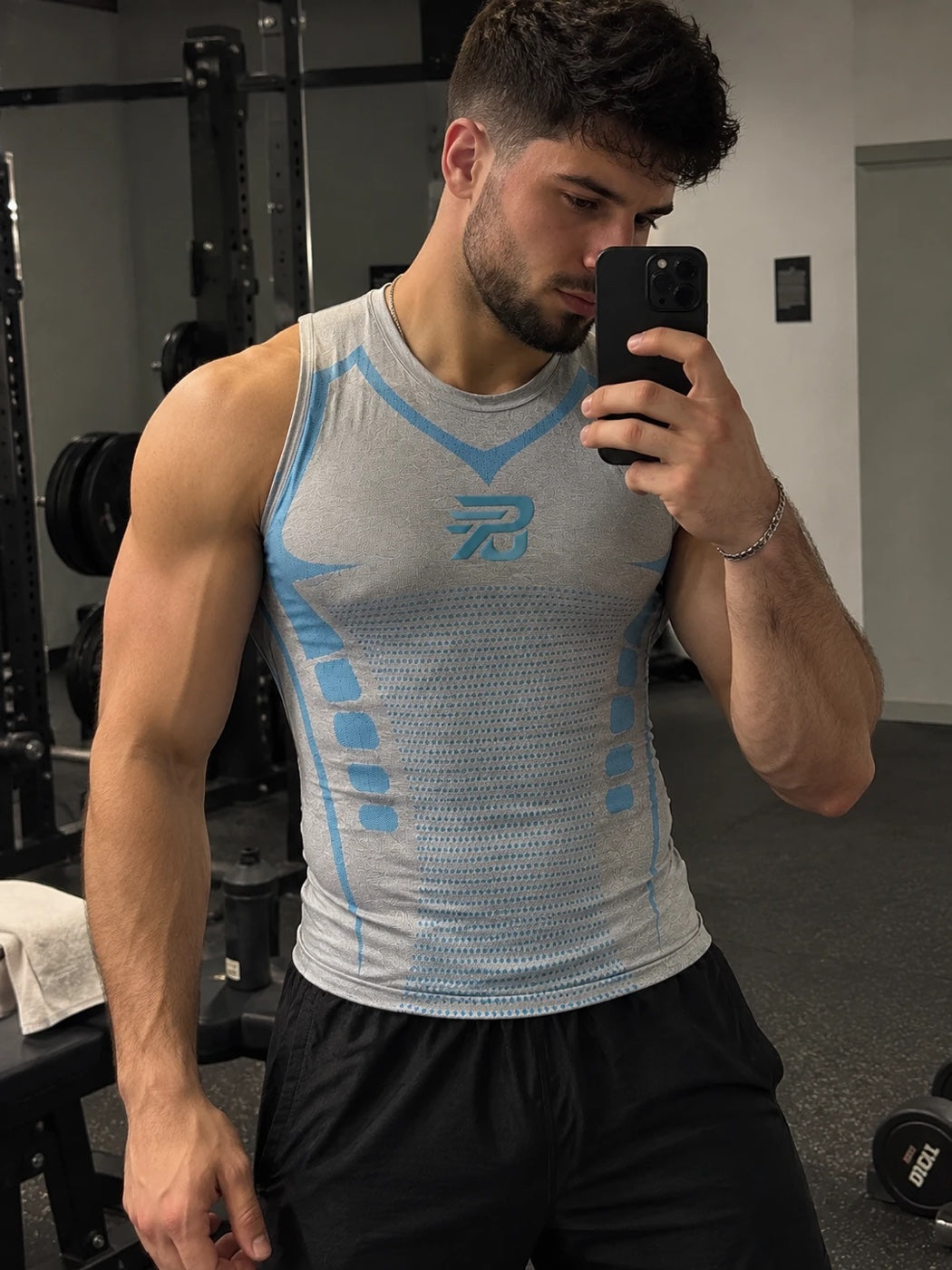 Client portant le débardeur de compression PORTEUNDER gris à la salle de sport